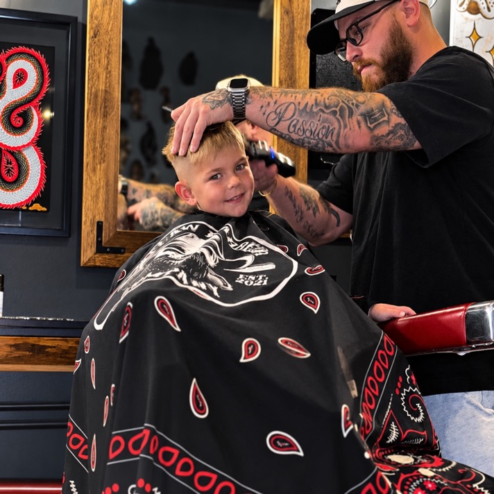 Jordan Sabatini cutting a young client's hair at Outlaw Barber Company Summerville